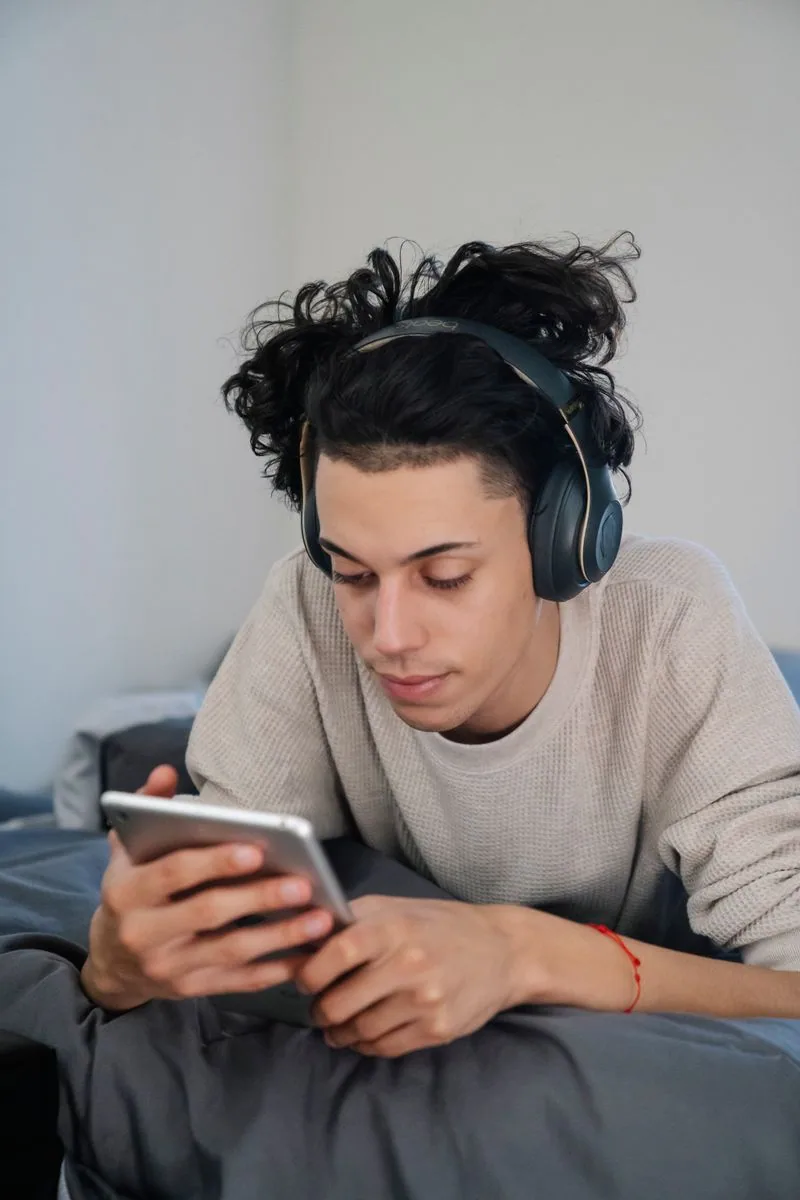 A notebook and Lifehear headphones beside a listening chair